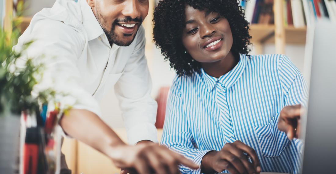 Two people looking at the computer.