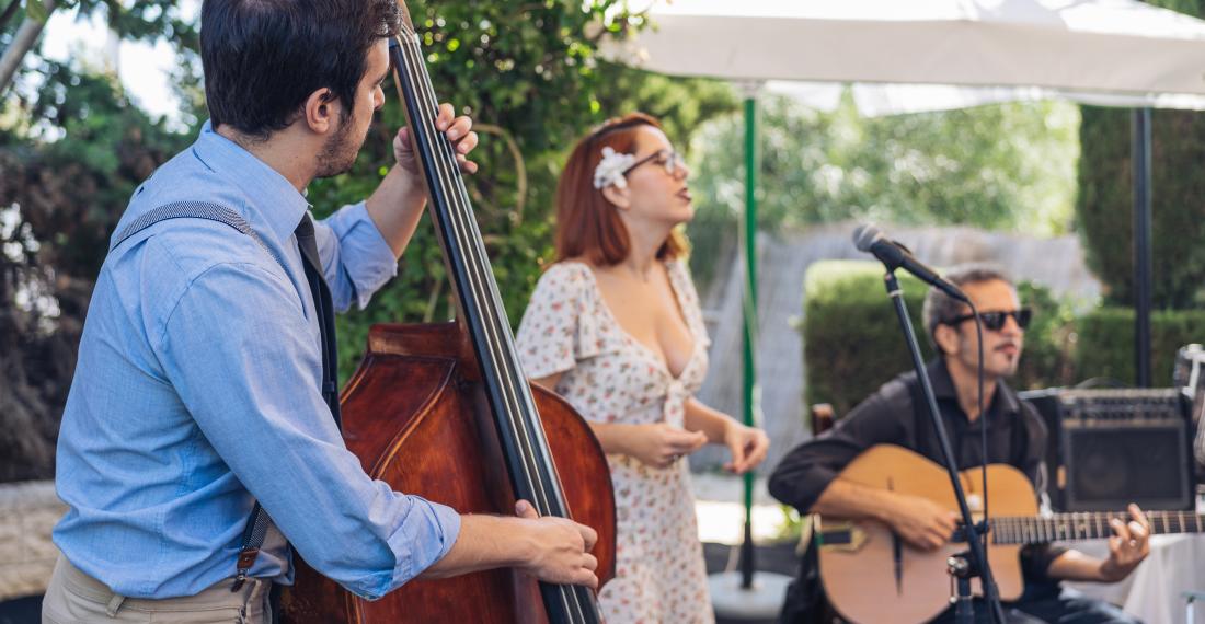 Woman singing while two men play instruments.