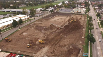 An empty dirt lot with construction vehicles on it.